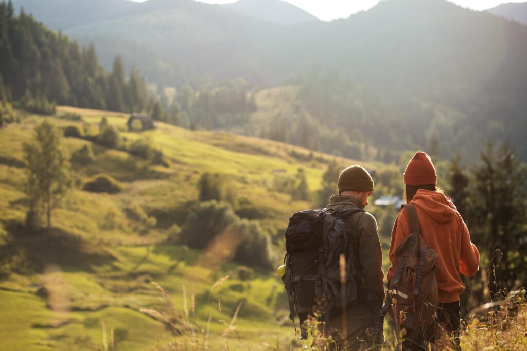 équipement randonnée montagne : deux randonneurs de dos face aux montagnes